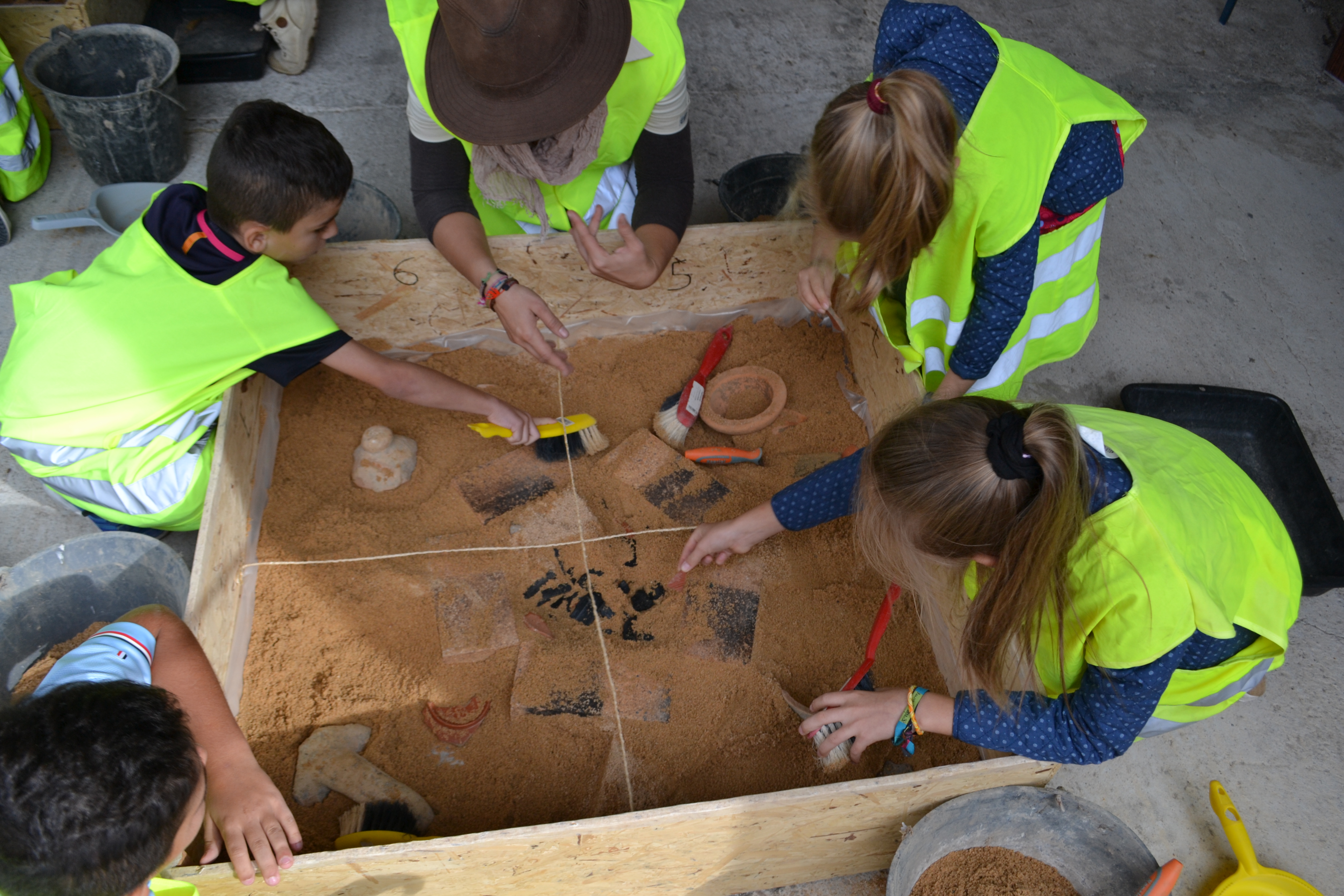 Des archéologues et des enfants font des fouilles au musée archéologique Lattara